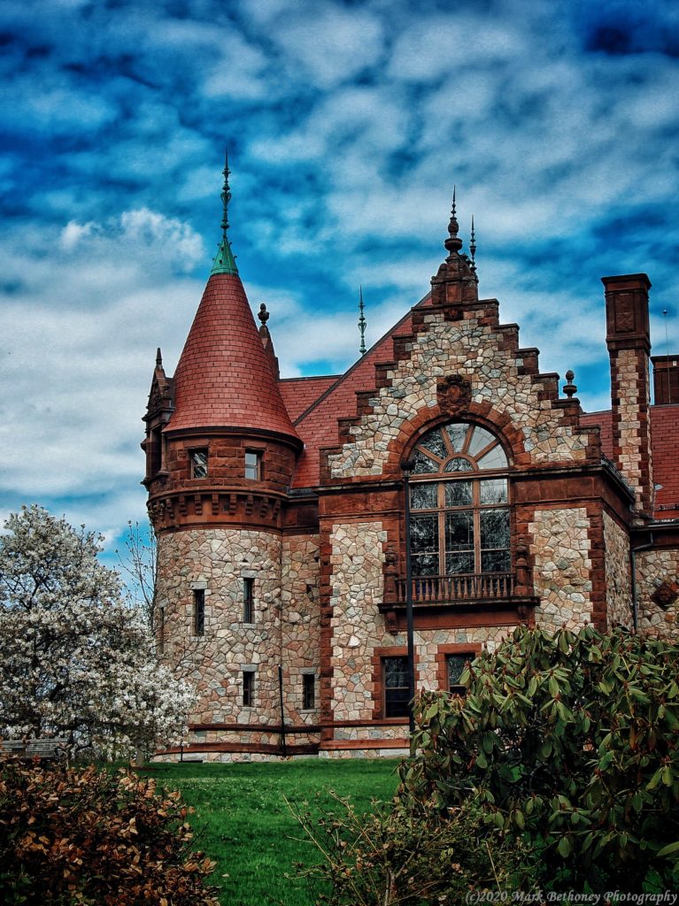 An image of a castle looking building with a blue sky behind it.