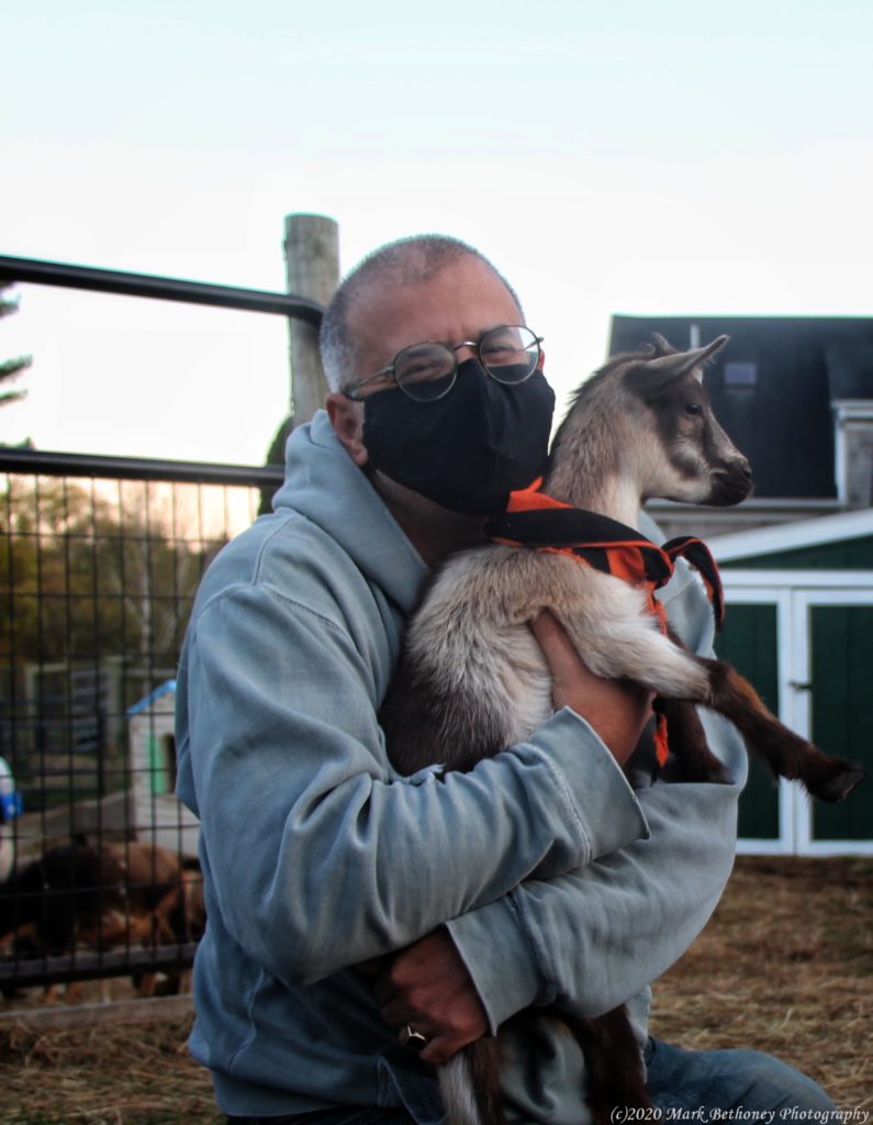 An image of the author cuddling a baby goat. An image of the author cuddling a baby goat.